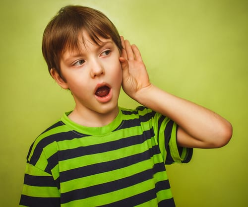 Young boy touching his ear