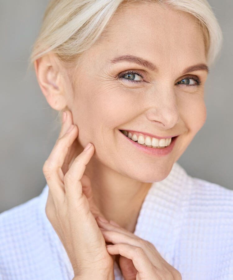 Woman smiling and touching her face