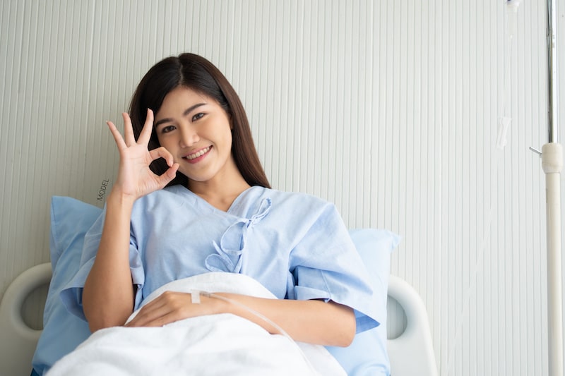 Woman sitting up in a hospital bed.