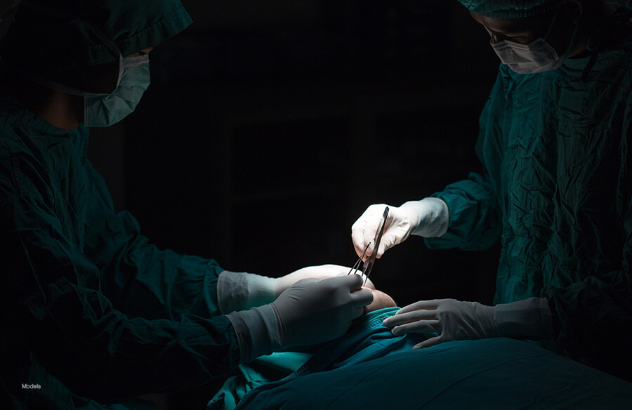 Skilled surgeons performing a cosmetic surgical procedure on their patient.