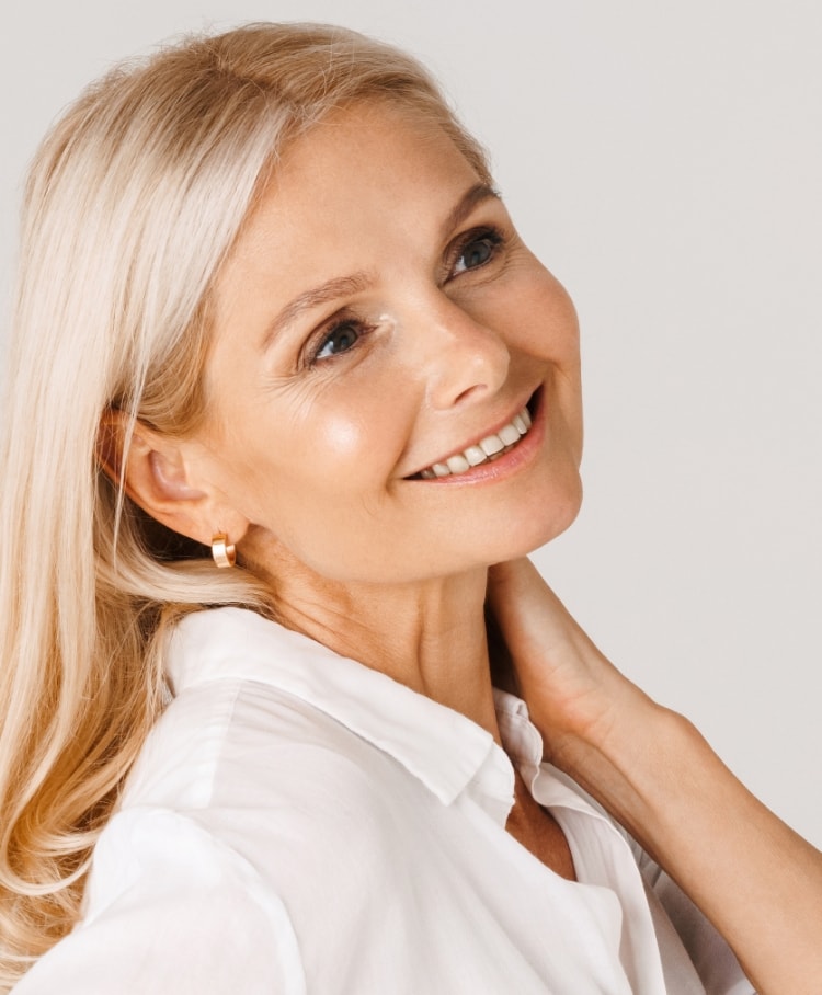 Mature woman in a white top smiling